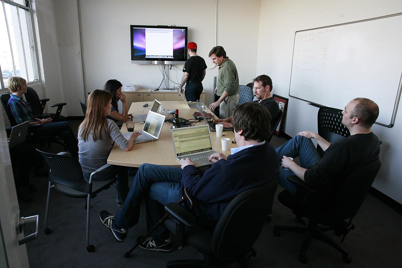 Colleagues in an office meeting room discussing strategy